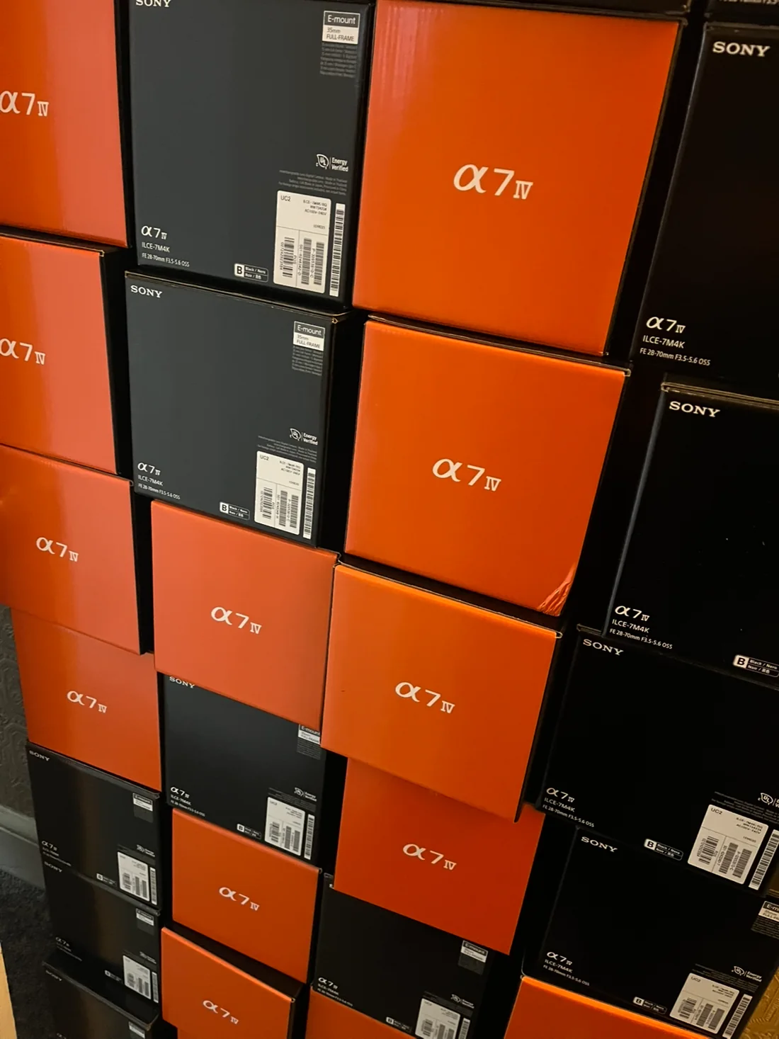 Stacked orange and black Sony A7 IV camera boxes.
